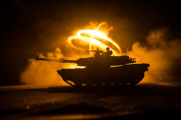 War Concept. Armored vehicle silhouette fighting scene on war foggy sky background at night. American tank ready to fight.