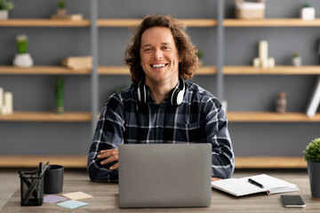 Poster - Portrait Of Successful Millennial Businessman At Laptop Sitting In Office