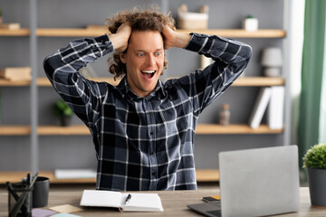 Poster - Excited Businessman Looking At Laptop Sitting In Modern Office
