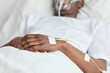 © Seventyfour - Close up of unrecognizable African-American man lying in white hospital bed with focus on iv drip catheter in hand, copy space