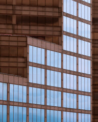 Wall Mural - Geometric architectural abstract of reflective blue windows against brown wall of a contemporary office building