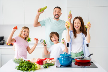 Sticker - Photo portrait of funny family cooking meal together keeping fresh vegetables for salad laughing fooling on white kitchen