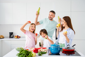 Sticker - Photo portrait of funny family cooking meal together keeping vegetables for salad fooling laughing before breakfast