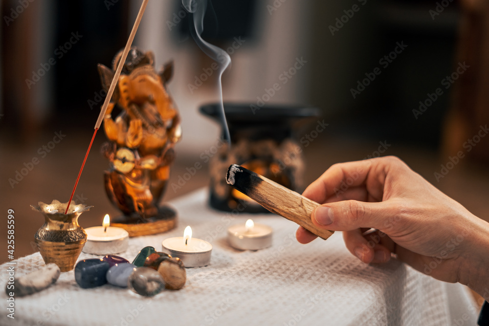 Palasata's wand slowly smoulders with smoke near the meditation altar - obrazy, fototapety, plakaty 