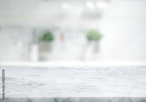 Selective focus.Marble table top on blur white kitchen room background.