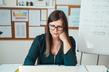 Female professor holding online class for e-learning students during pandemic period.
University teacher, college tutor explaining physics giving remote school class online lesson on laptop at home