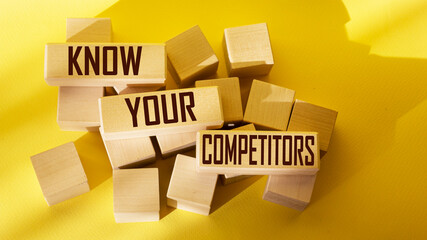 Wall Mural - the text know your competitors is written on wooden blocks and on a yellow background.