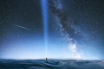 Wall Mural - fantasy night landscpe. the person with flash light stands on the hill covered long exposhur clouds.