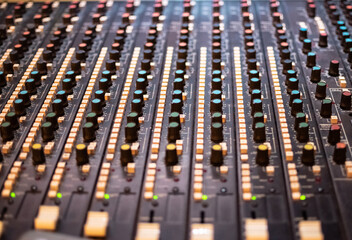 Recording with an audio mixing console turned on, using different faders, buttons and knobs