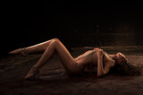 Beautiful nude woman chained on floor looks away