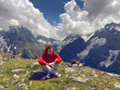 © Anton Dios - Young man sitting on mountain peak in cloudy weather. Adult guy rests, enjoying amazing mountain landscape in summertime.