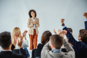 multicultural group of business people cheering and clapping to a mixed race businesswoman who just 