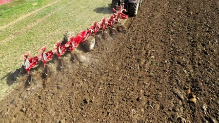 Wall Mural - Aerial view to tractor with plough working on a field. Farmer use manure for organic growing.  Agriculture from above. Environmentally friendly farming.