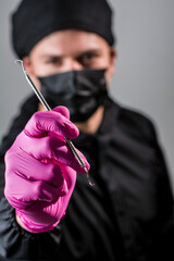 dentist posing with syringe, uniform, gloves, teeth and other instruments