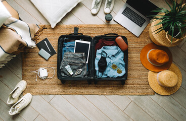 packing suitcase for travel vacation in new normal, top view.