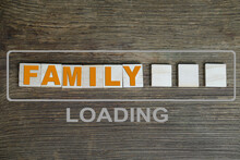 Word Family Made Of Volumetric Colored Letters On A Dark Wooden Background, Concept Of Marriage, Weddings, Honeymoon Time, Content Loading Process