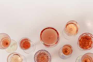 Poster - Rose wine assortment in crystal glasses, rose champagne sparkling wine on light background. Summer alcoholic drink