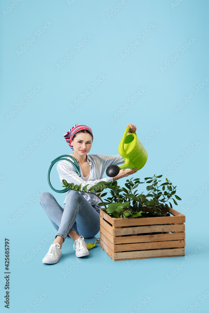 Young female gardener on color background - obrazy, fototapety, plakaty 