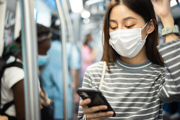 Young asian woman cover mouth , wear medical face mask to protect viruses.standing distance of 1 meter from other people keep distance protect from COVID-19 viruses.social distance.