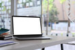 © Prathankarnpap - Close up view computer laptop with empty screen and books on white table in conference room.