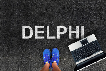 Poster - Delphi programming language. man legs in sneakers standing next to laptop and word Delphi
