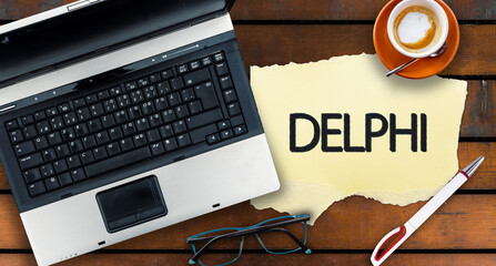 Poster - Delphi programming language. Word Delphi on paper and laptop