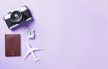 Top View Flat Lay Mockup Of Retro Camera Films, Airplane, Passport Travel Accessories Isolated On A Purple Background With Copy Space, Business Trip, And Vacation Summer Travel Concept