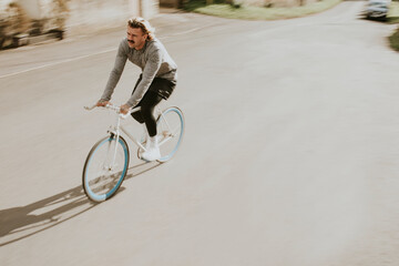 Urban man with mustache riding a bicycle on the streets