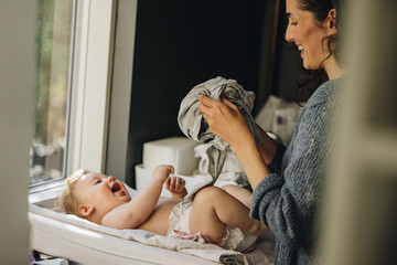 Mother getting her baby dressed