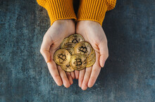 Overhead View Of Two Hands Full Of Bitcoins On A Textured Background. Golden Coins BTC, Stock Market Of Cryptocurrencies Concept And Digital Decentralized Finances Concept