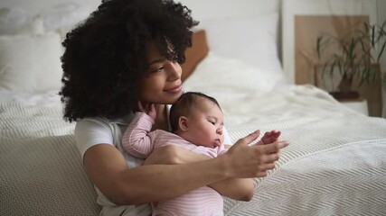 family of mom and baby girl having good time together and sitting on bed in home bedroom spbd.