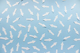 Fototapeta Do przedpokoju - Concept of chaos randomly arranged many white paper arrows on blue background.