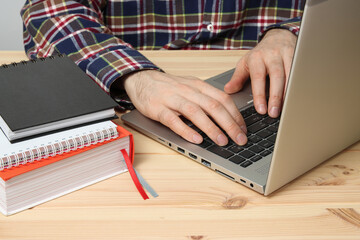 Man is typing something on the laptop, working or studying theme