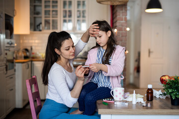 Mother looking after sick small daughter at home.