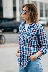 Canvas Print - Fashion portrait of beautiful woman with beautiful face, wearing grunge plaid shirt. Posing alone.