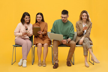 Wall Mural - People waiting for job interview on yellow background