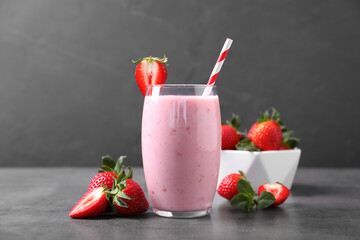 Delicious strawberry drink in glass on grey table