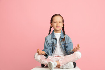 Wall Mural - Happy kid, girl isolated on pink studio background. Looks happy, cheerful, sincere. Copyspace. Childhood, education, emotions concept