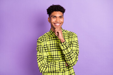 Wall Mural - Photo of smart minded young afro american man hold hand chin smile isolated on purple color background