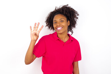 Wall Mural - young beautiful African American woman wearing pink t-shirt against white wall showing and pointing up with fingers number four while smiling confident and happy.