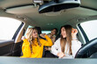 © F8  \ Suport Ukraine - Group of three women having fun in the car. Women friends singing songs and dancing in car during road trip.