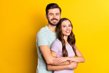 Poster - Portrait of attractive cheerful couple embracing spending day time honeymoon holiday isolated over bright yellow color background