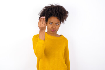 Wall Mural - young beautiful African American woman wearing yellow sweater against white wall Doing Italian gesture with hand and fingers confident expression