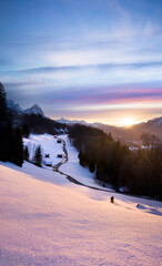 Wall Mural - beautiful pink sunset in the mountains with leading line road towards church and motorbiker having f