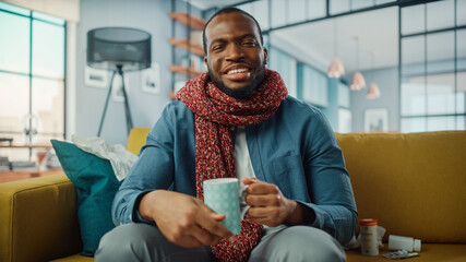 Aufkleber - Ill and Tired Black African American Calling into Office with Video Call on Laptop from Cozy Living Room. Sick and Nauseous Male in Warm Scarf Talking to Friend Over a Live Camera.