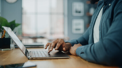 Aufkleber - Close Up on Hands of a Black African American Man Working on Laptop Computer while Sitting Behind Desk in Cozy Living Room. Freelancer Working From Home. Browsing Internet, Using Social Network.