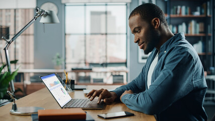 Aufkleber - Handsome Black African American Specialist Working on Laptop Computer in Creative Home Living Room. Freelance Male is Doing Market Analysis and Creates Report with Charts for Clients and Employer.