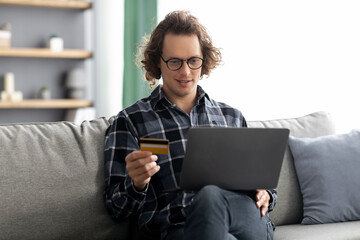 Poster - Guy Using Credit Card And Laptop Shopping Online At Home