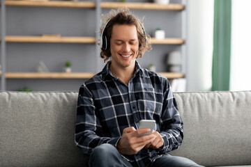 Poster - Happy Man Listening To Music On Phone Sitting At Home