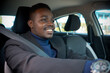 © arrowsmith2 - African man in a black suit sitting behind the wheel with smile and happy